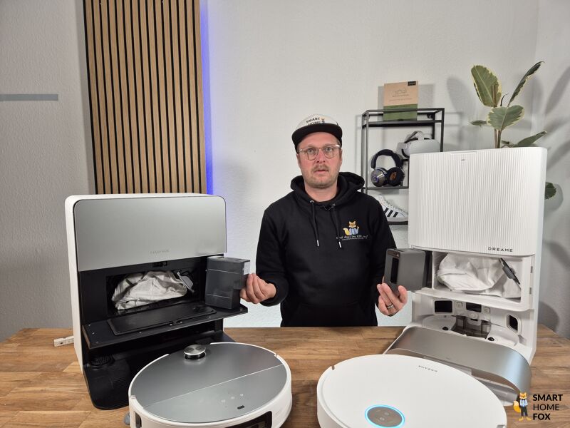 Die Reinigungsmittel Kartusche des Dreame X50 Ultra und des Roborock Saros 10 werden in den Händen gehalten.